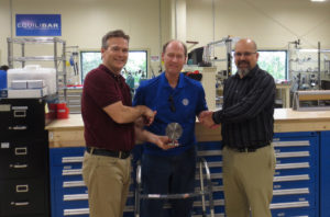 Equilibar President Jeff Jennings, left, and Operations Manager David Reed, right, offer best wishes to Myron Redden. 